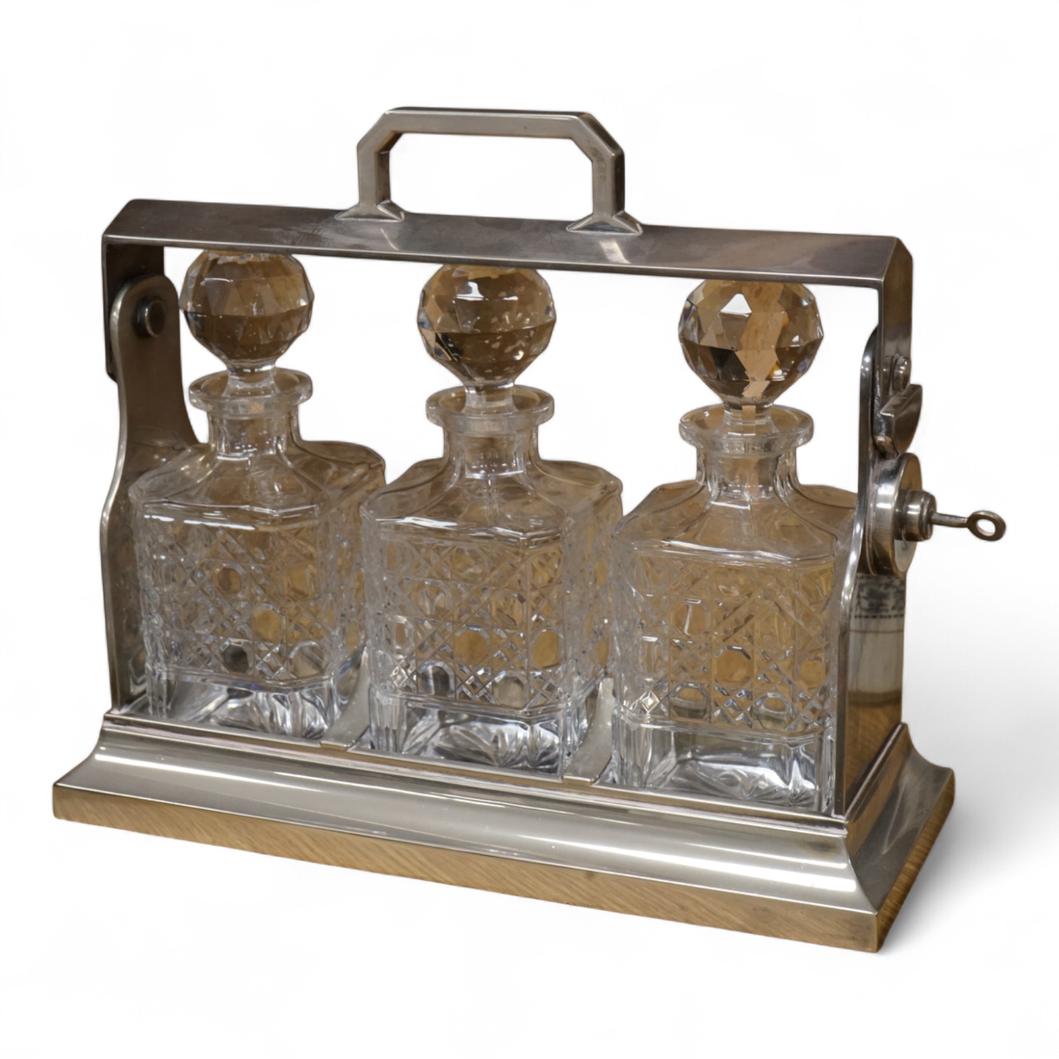 A silver plated three bottle tantalus, 34cm wide.